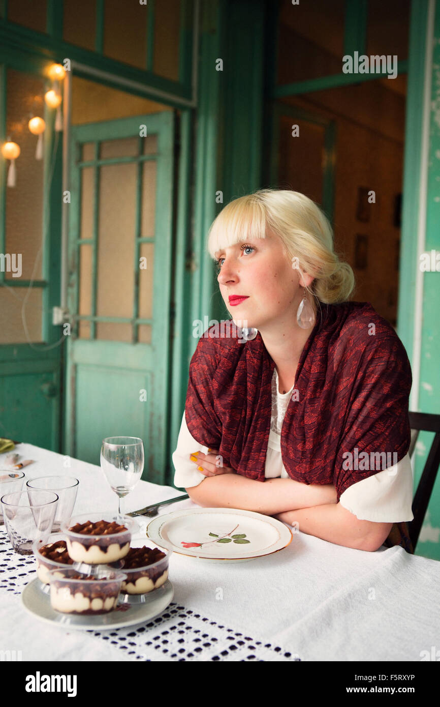 France, Languedoc-Roussillon, jeune femme assise seule à la table Banque D'Images