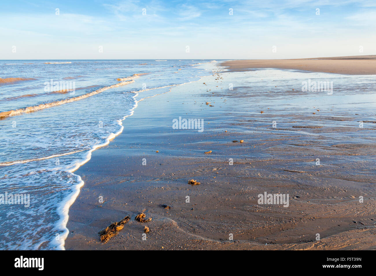 Le flux et le reflux d'une mer calme. Petites vagues au cours d'une marée descendante sur une soirée d'été à Gibraltar Point, Lincolnshire, Côte Est, England, UK Banque D'Images