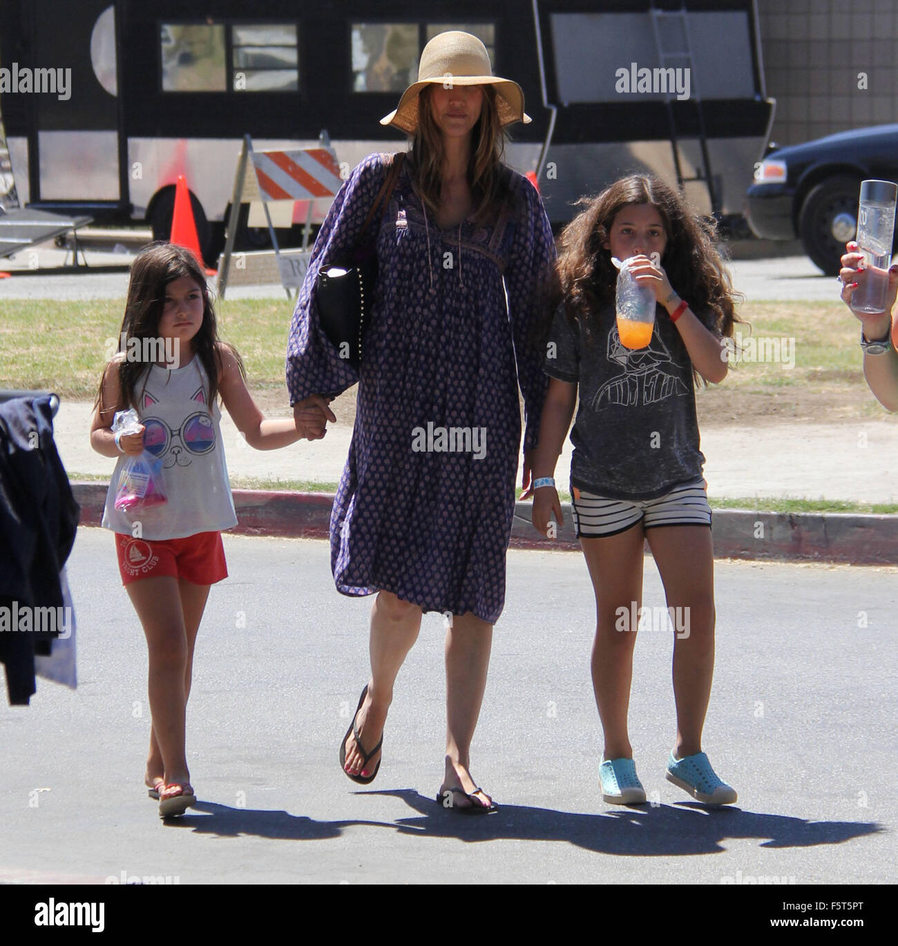 Adam Sandler portant un grand chapeau de paille va dehors et environ à  Malibu avec sa femme et ses filles avec : Jackie Sandler, Sadie Madison  Sandler, Sunny Madeline Sandler Où :