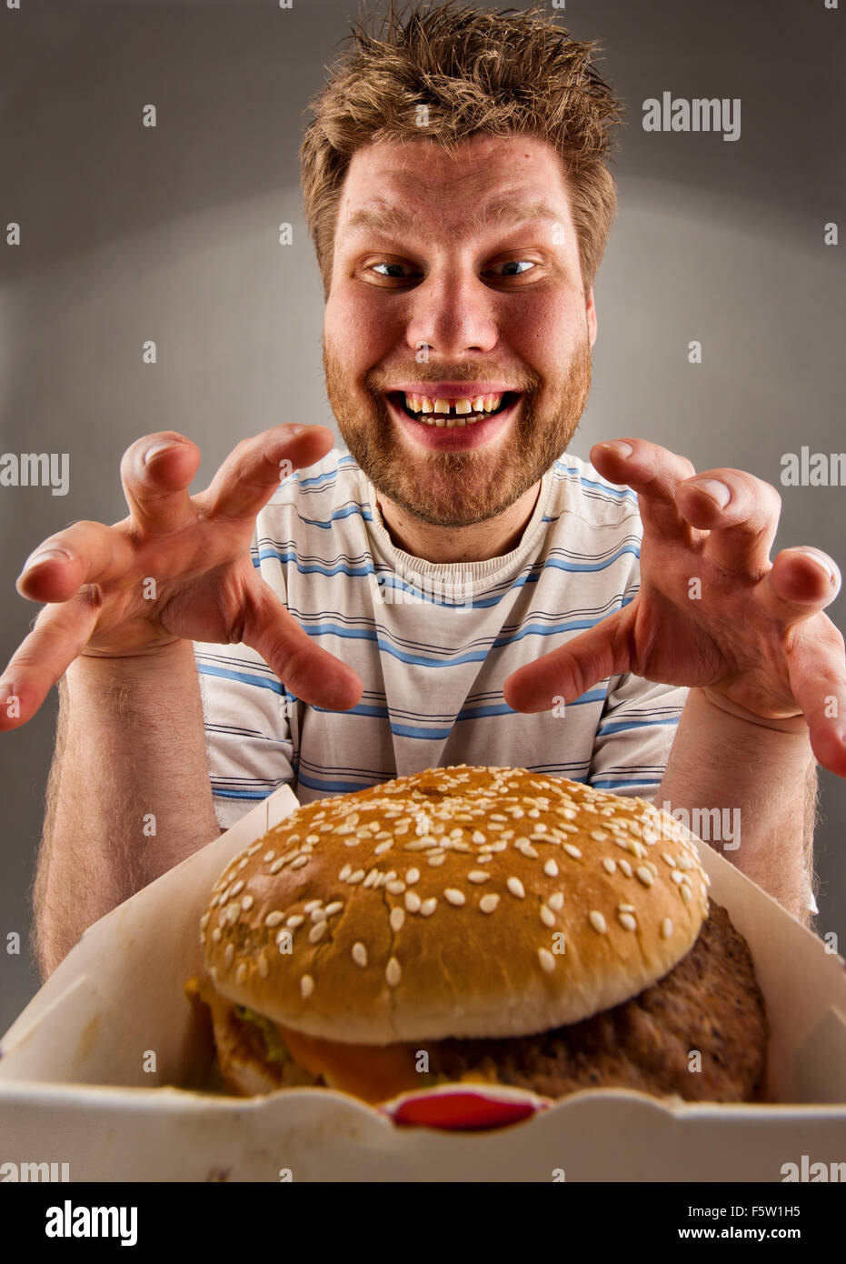 Portrait d'homme heureux prépare à manger burger Banque D'Images