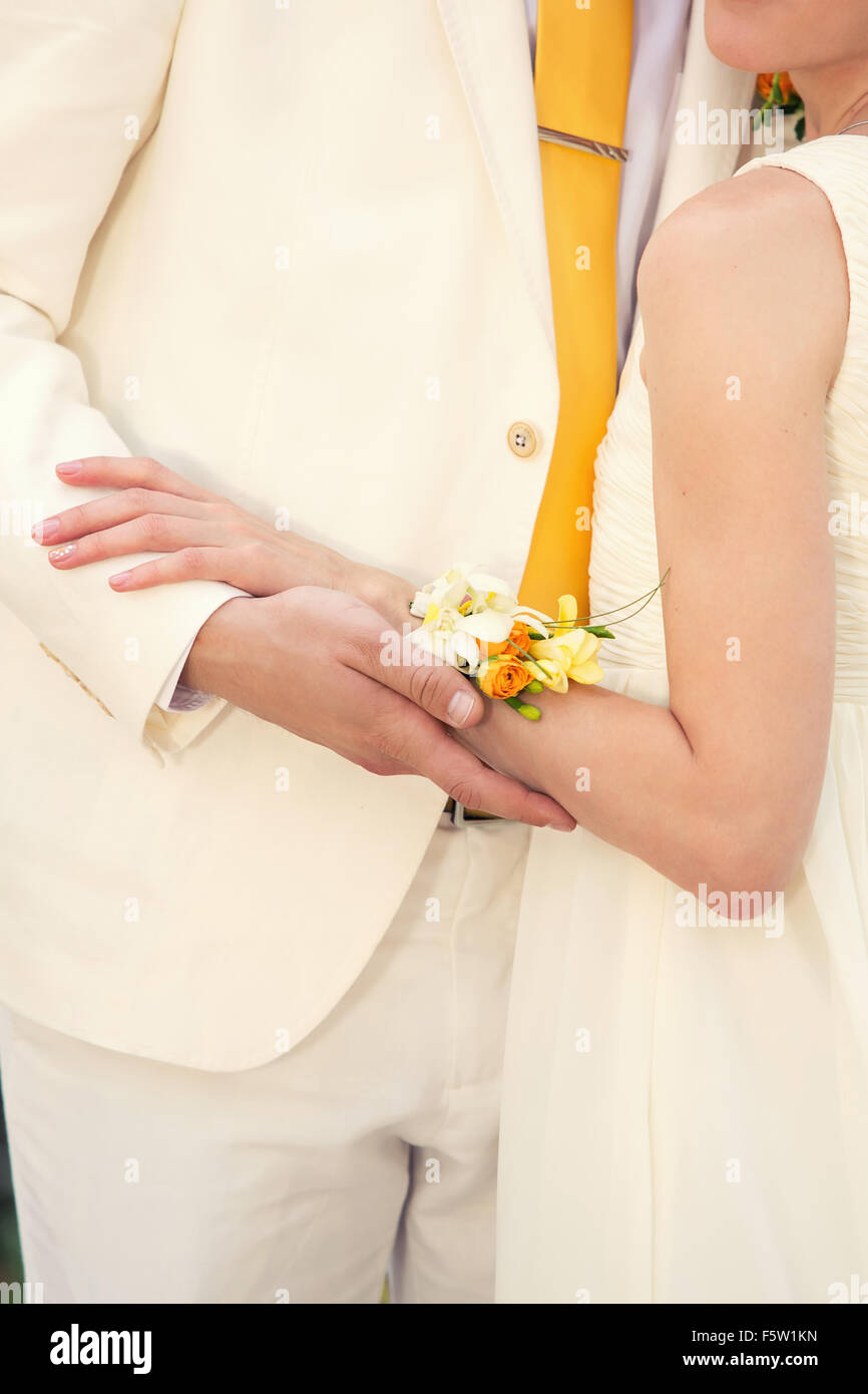 Mariée avec bracelet jaune sur son bras serrant la mariée dans un costume de lumière Banque D'Images