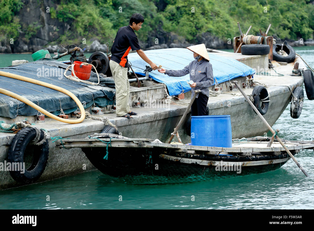 L'achat de femme l'eau douce du bateau en béton, village de pêcheurs de Vung Vieng, Ha Long Bay, Secteur de Bai Tu Long, près de Ha Long, Vietnam Banque D'Images