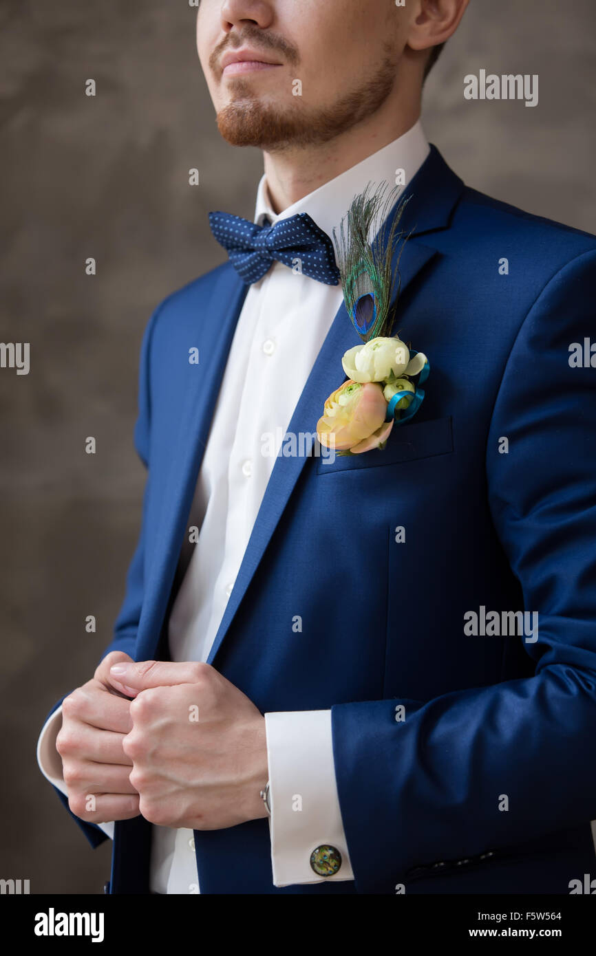 Mariée élégante dans un costume bleu et boutonnière en une queue du paon Banque D'Images