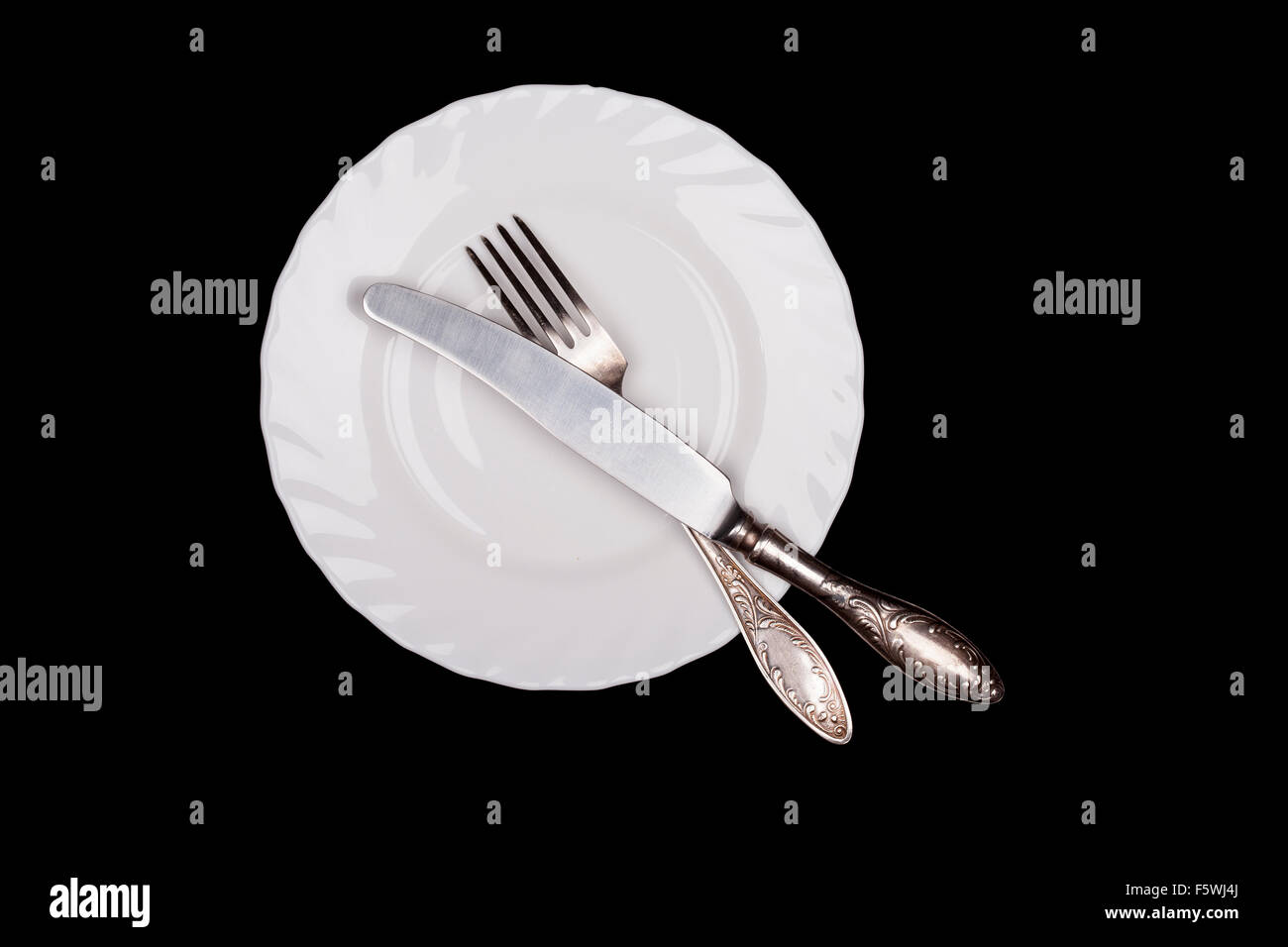 Signe de l'étiquette. Assiette, fourchette, couteau top view isolated on black Banque D'Images