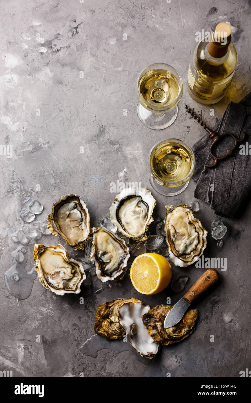 Ouvert les huîtres de Claire des amendes et le vin blanc sur fond de texture de béton gris Banque D'Images Ouvert les huîtres de Claire des amendes et le vin blanc sur fond de texture de béton gris Banque D'Images