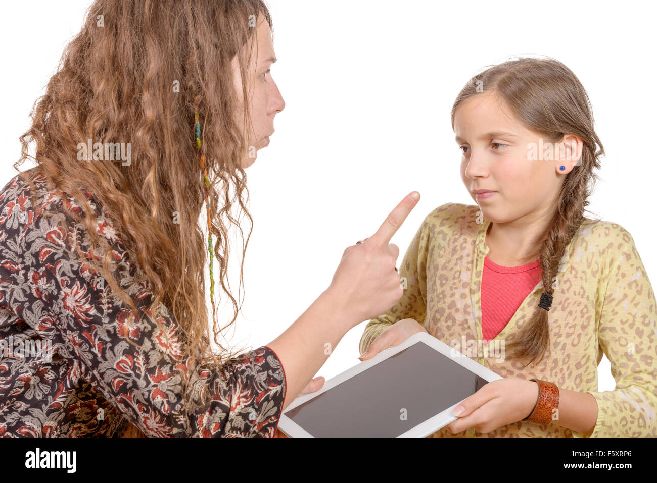 Les réprimandes de la mère en colère fille parce qu'elle palaying avec une tablette numérique Banque D'Images