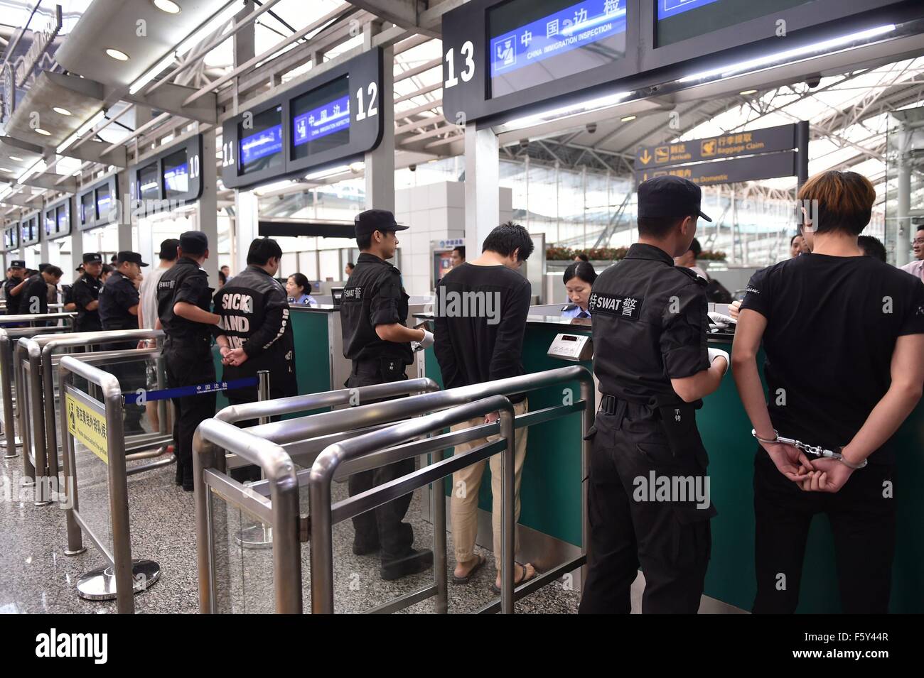 (151110) -- Guangzhou, le 10 novembre 2015 (Xinhua) -- les suspects impliqués dans des cas d'escroquerie de télécom sont accompagnés jusqu'à passer la douane par la police à l'Aéroport International de Guangzhou Baiyun à Guangzhou, capitale du sud de la province chinoise du Guangdong, le 10 novembre 2015. Un total de 254 suspects du continent chinois impliqués dans telecom escroquerie cas ont été envoyés en Chine le mardi matin à partir de l'Indonésie et le Cambodge, sous l'escorte de la police chinoise, selon le ministère de la sécurité publique. Les suspects sont impliqués dans plus de 4 000 grandes fraudes liées aux télécommunications sur une provinciale 20 Banque D'Images