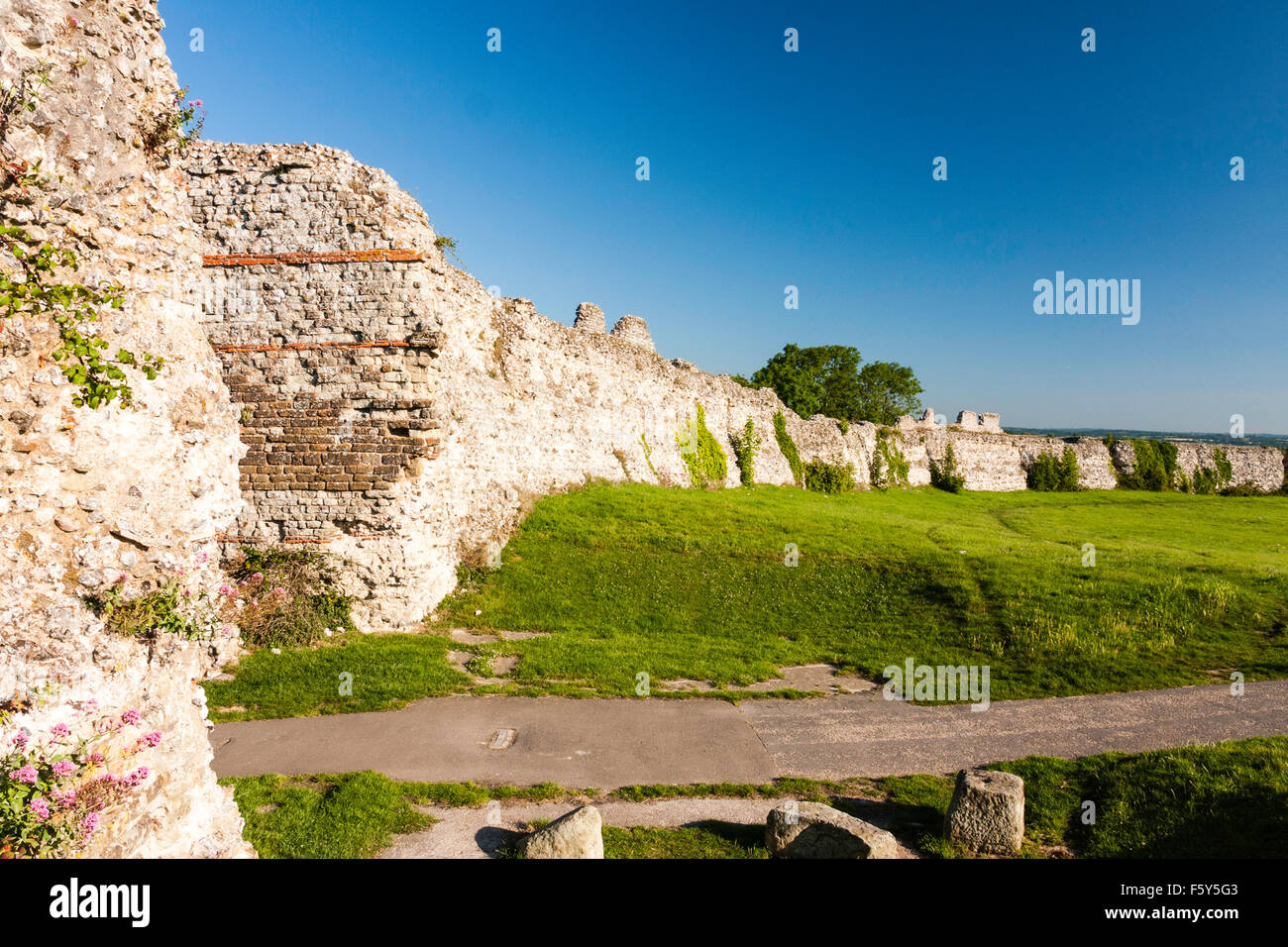Saxon Shore romain 4ème siècle, château fort Pavensey. Ruines de l'épaisseur des murs avec porte ouest entrée, et ciel bleu clair au-dessus. L'ensoleillement. Banque D'Images