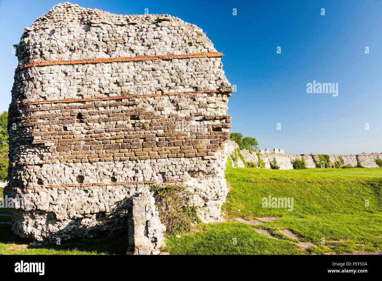Saxon Shore romain 4ème siècle, château fort Pavensey. Ruines de l'épaisseur des murs avec porte ouest entrée, et ciel bleu clair au-dessus. L'ensoleillement. Banque D'Images