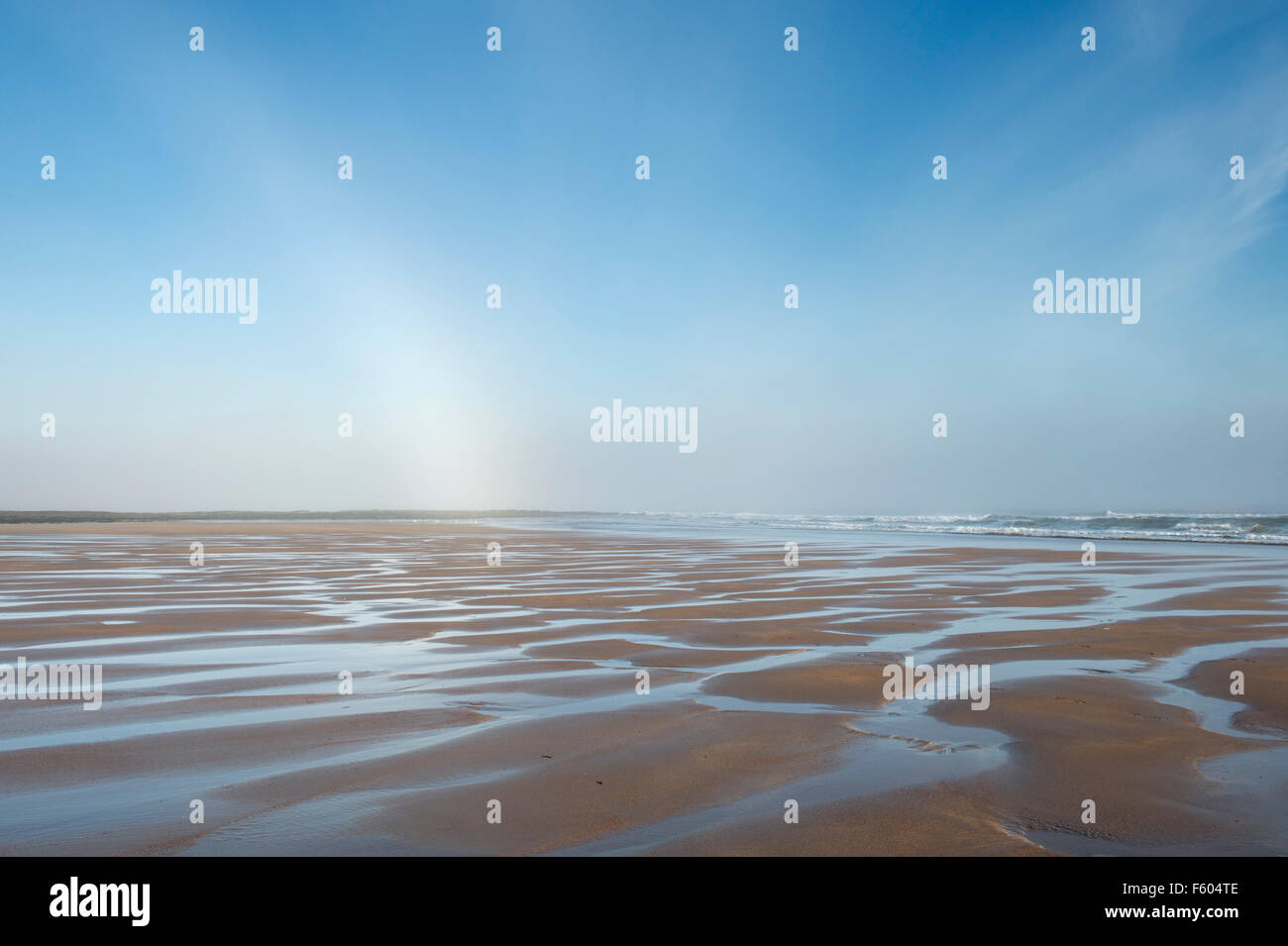 Mer et Ciel nuageux réflexions sur la plage. Scremerston, Weymouth, Dorset, Angleterre. Banque D'Images