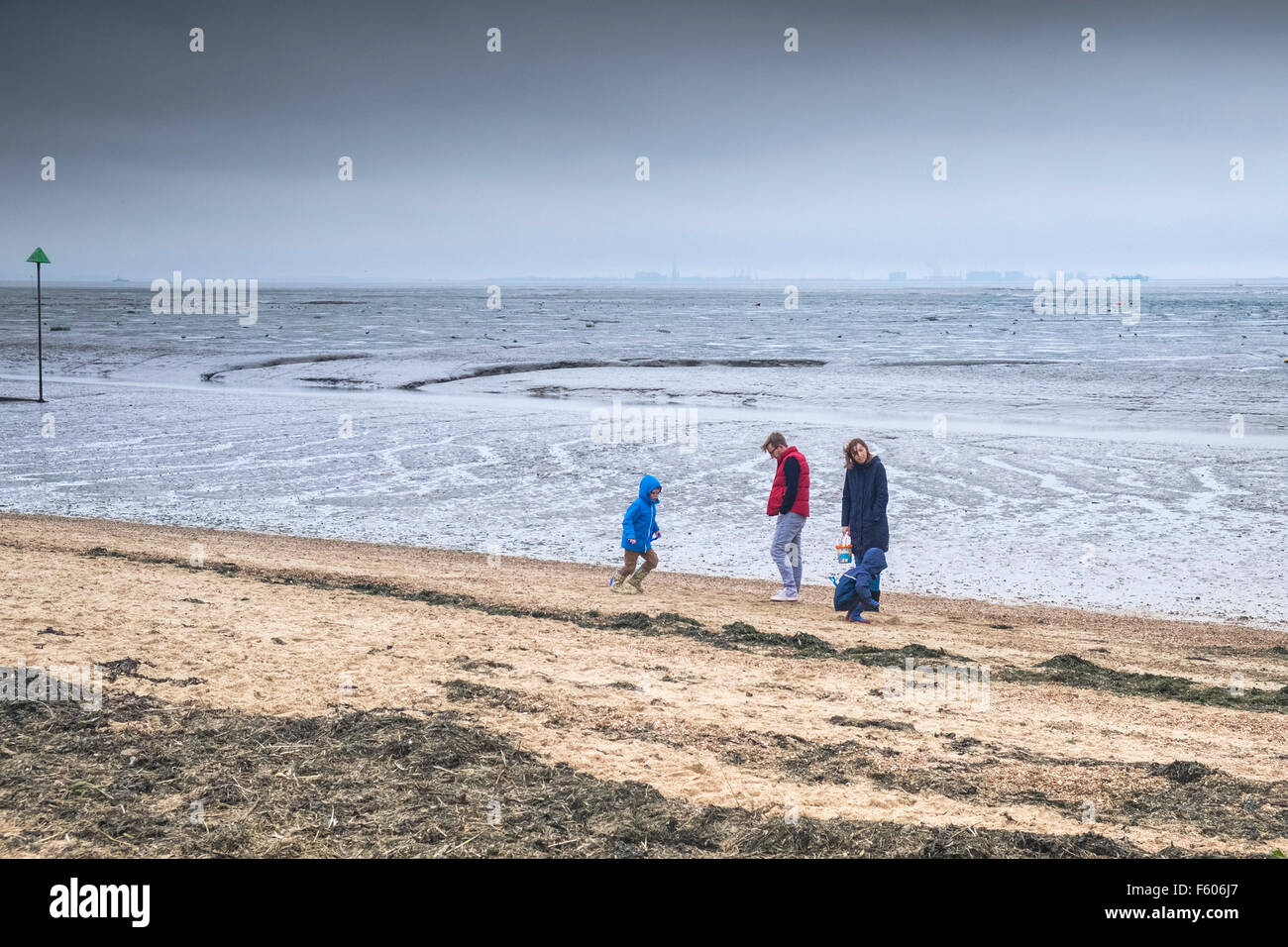 Une famille brave le froid sur le quai de Bell Plage de Leigh on Sea, Essex. Banque D'Images