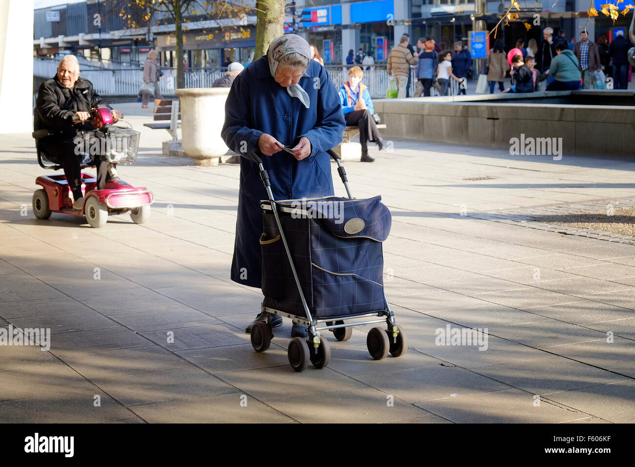 Une vieille dame debout dans le centre-ville de Basildon, Essex. Banque D'Images