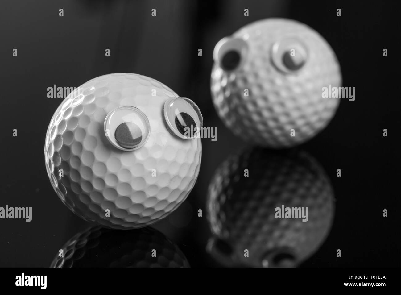 Deux balles de golf avec les yeux sur fond gris Banque D'Images