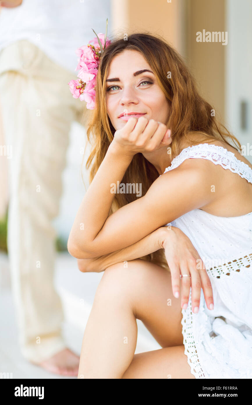 Belle belle femme avec cheveux fleur accessoire sur la rue sur une journée ensoleillée Banque D'Images