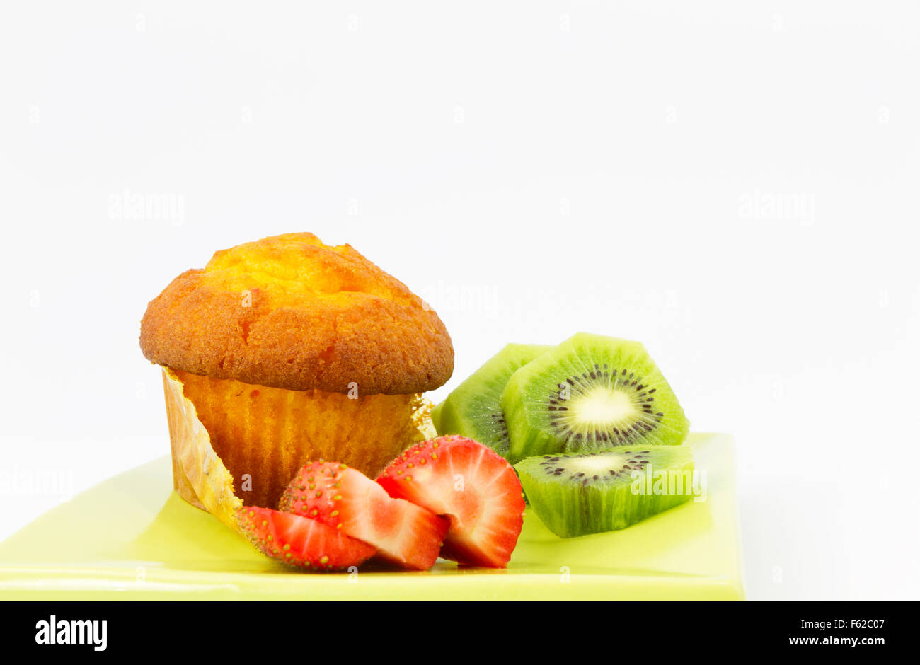 Muffin au maïs délicieux avec des tranches de kiwi et de fraise. Des fruits sains, savoureux et cuit les aliments sur la plaque verte. Banque D'Images