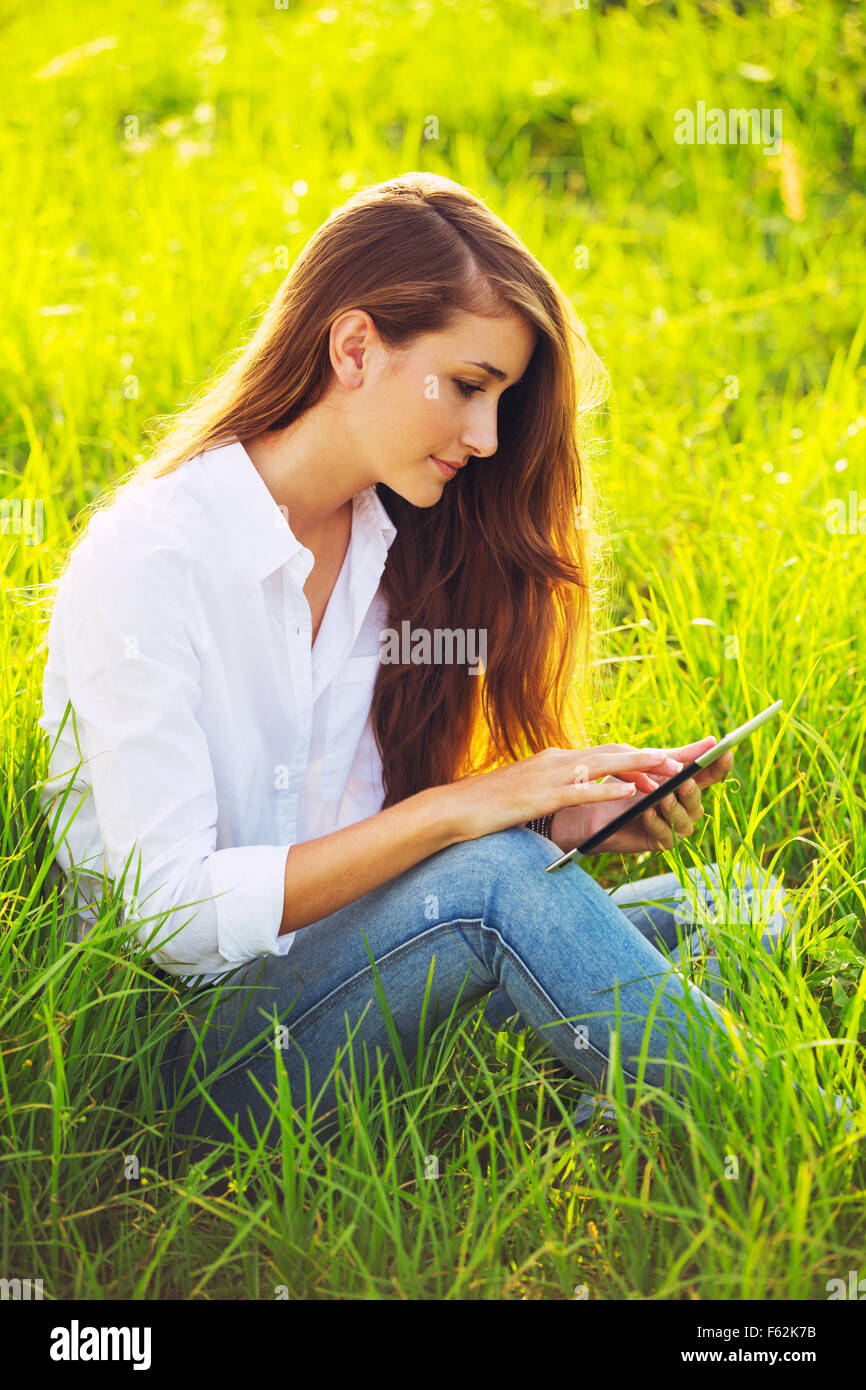Happy Young Woman Using Tablet Outdoors Banque D'Images