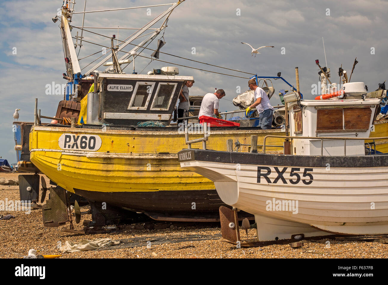 Nettoyer les bateaux de pêche sur la plage Hastings UK Banque D'Images