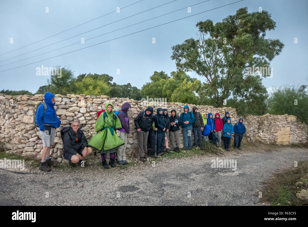 Les marcheurs tentent d'échapper à la pluie à Marsaxlokk dans le sud de Malte. Banque D'Images