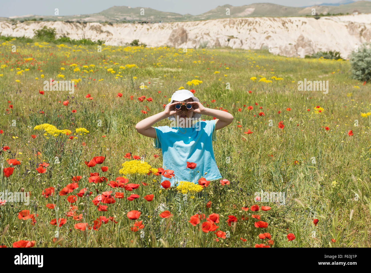 Little girl looking through binoculars outdoors Banque D'Images