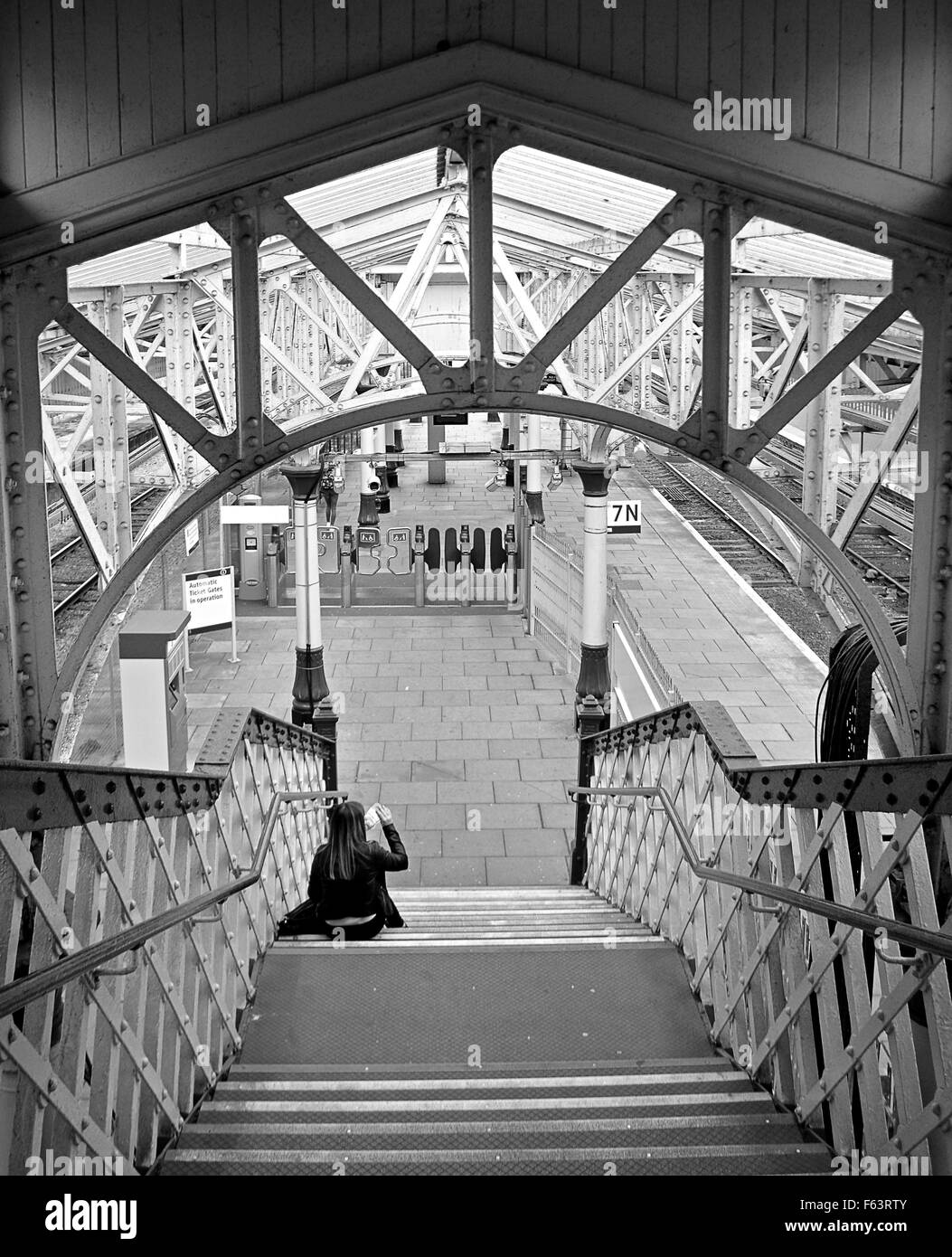Une fille attend un train par une plate-forme à la gare d'Aberdeen Banque D'Images