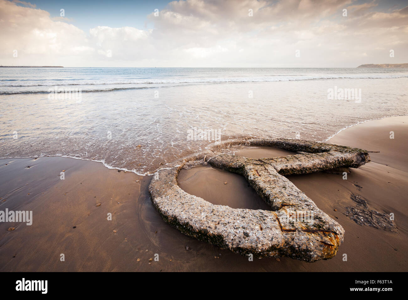 Côte de l'océan Atlantique, vieux béton construction repose sur le sable humide , Tanger, Maroc. Correction des tons chaleureux de stylisation, p Banque D'Images