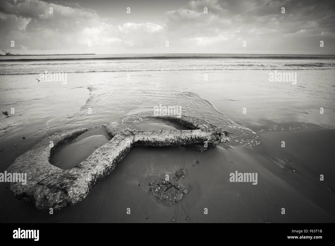 Côte de l'océan Atlantique, vieux béton construction repose sur le sable humide , Tanger, Maroc. Photo aux tons monochromes Banque D'Images