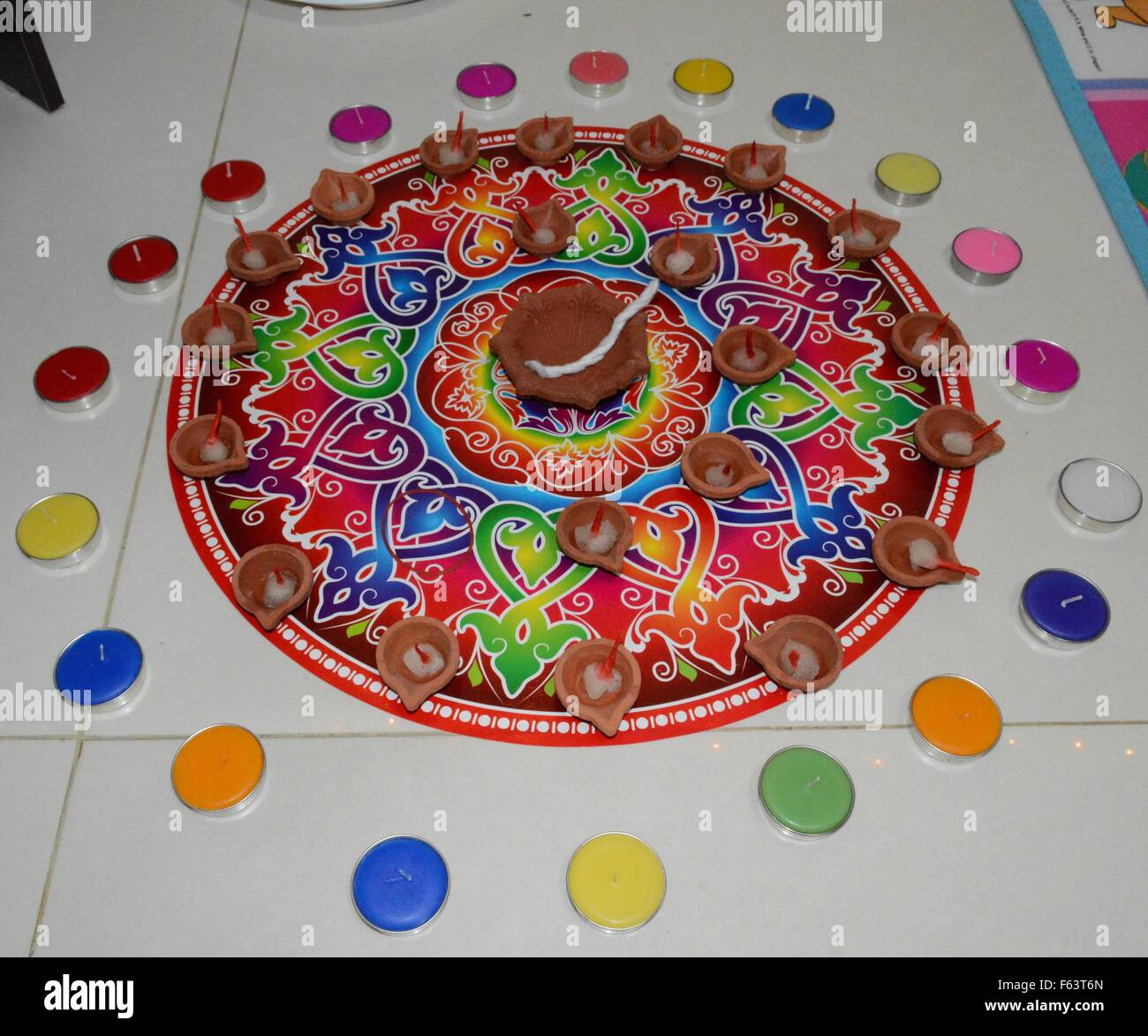 Rangoli dans un cadre coloré et arc-en-ciel en terre et multicolore avec diyas bougie Banque D'Images