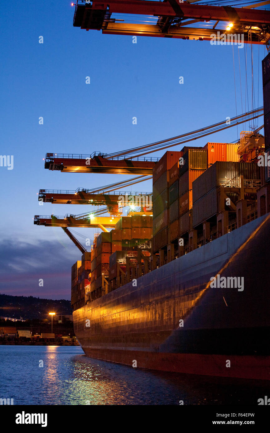 Chargement de conteneurs à des installations portuaires au crépuscule nuit Banque D'Images