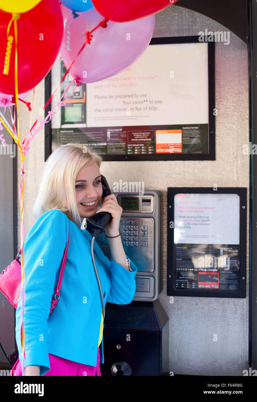 Party Girl en utilisant une fonction phonebox Banque D'Images