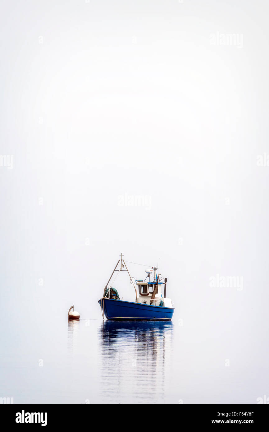 Un bateau de pêche sur une mer brumeuse Banque D'Images