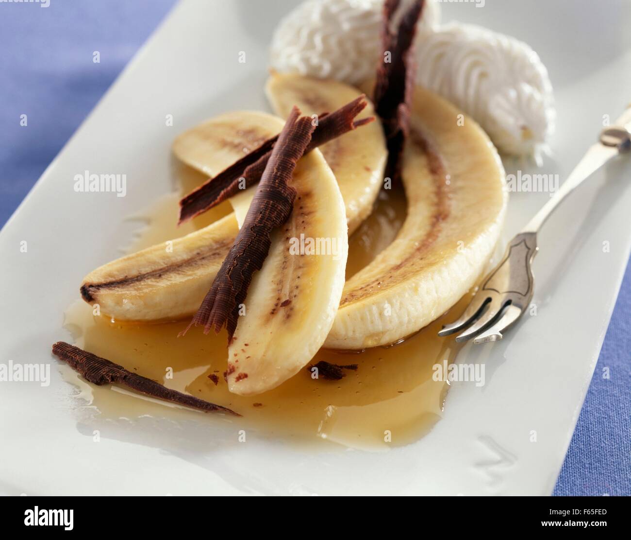 Banane avec le chocolat et crème fouettée Banque D'Images