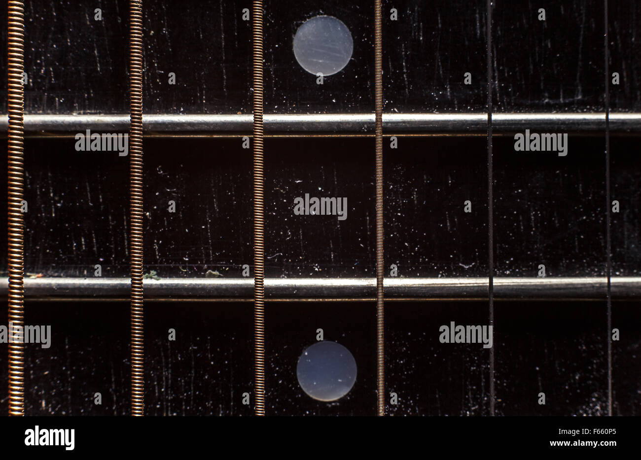 Six cordes et le cou d'une vieille guitare acoustique poussiéreux. Banque D'Images