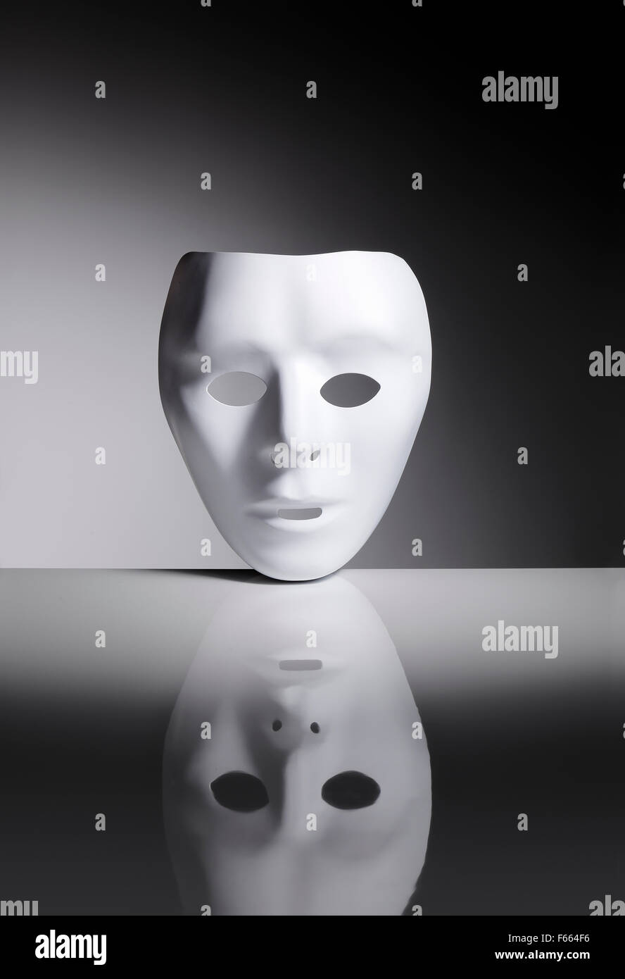 Masque en plastique blanc vide sur une surface réfléchissante. Banque D'Images