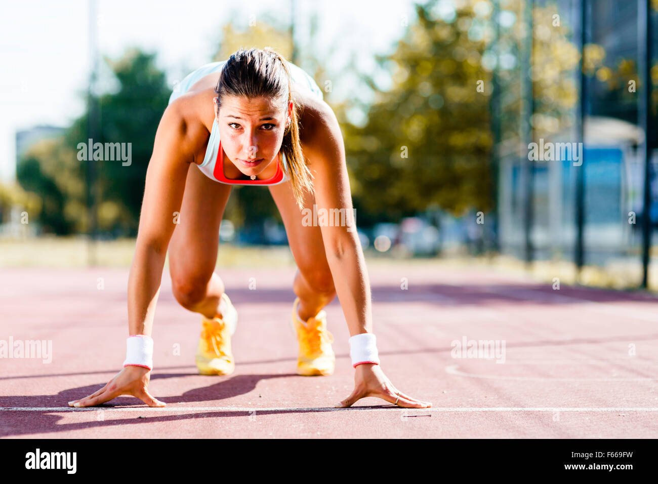 Belle femme sprinter se préparer pour l'exécuter au cours de l'été Banque D'Images