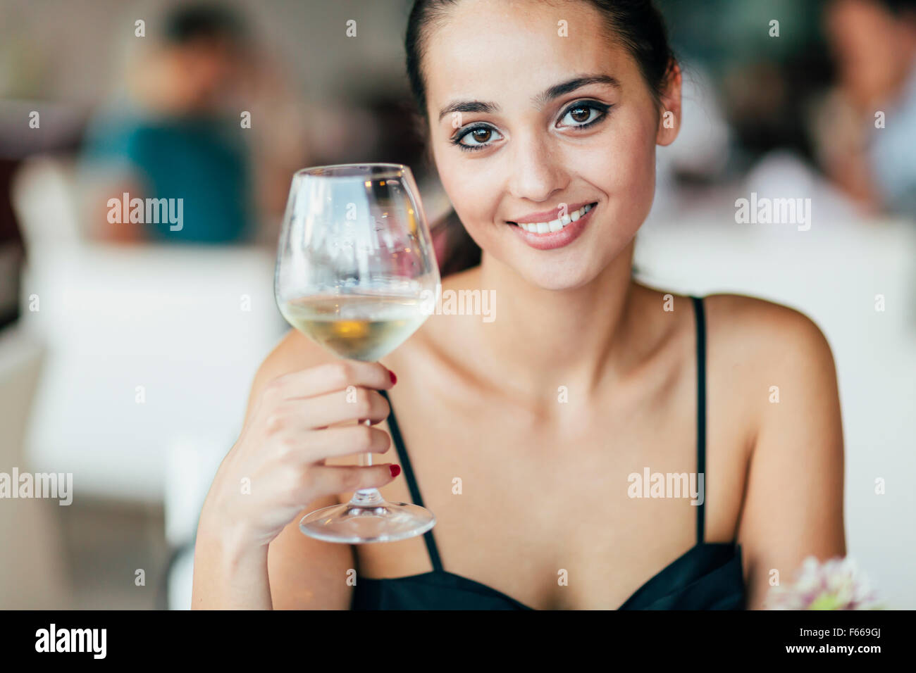 Dégustation de vin blanc femme en restaurant et en conséquence en verre de levage Banque D'Images