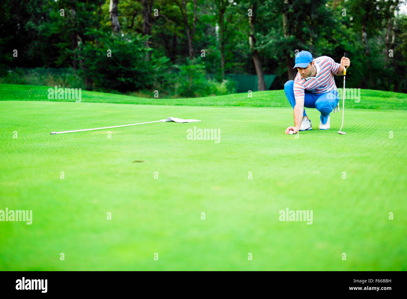 Joueur de golf ball marquage sur le vert avant de soulever la balle Banque D'Images