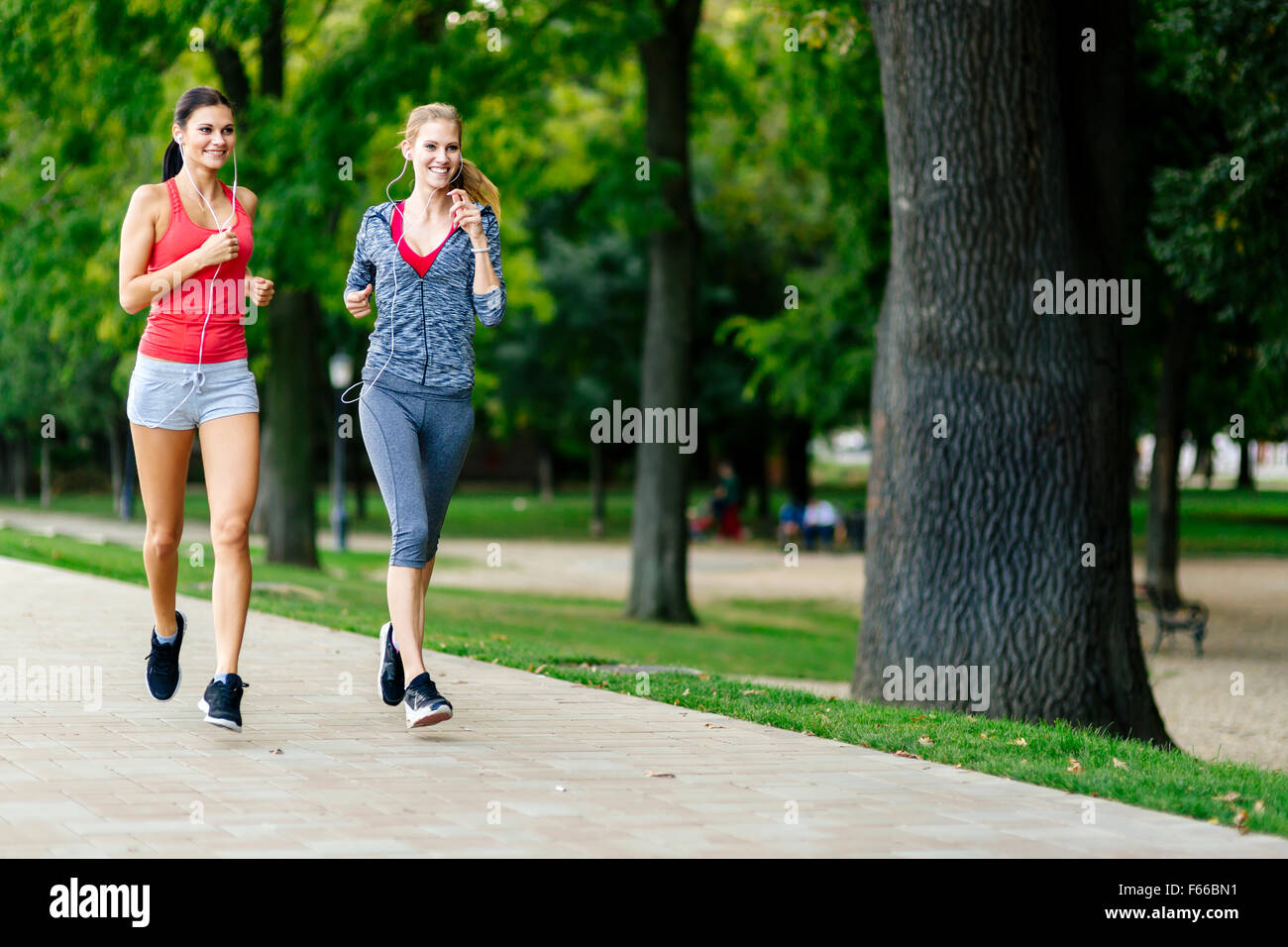 Deux femmes le jogging dans le parc et d'écouter de la musique Banque D'Images