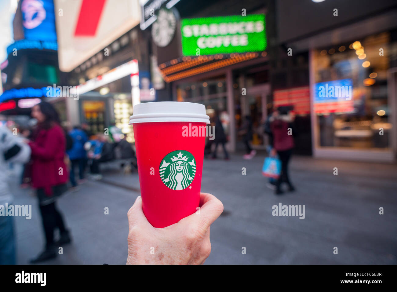 Un buveur de café Starbucks affiche sa tasse de café sur le thème de Noël à New York le dimanche, Novembre 8, 2015. Un groupe de chrétiens évangéliques est offensé par le retrait de l'«symboles de la saison' à partir de la tasse qui sont juste rouge vert et blanc avec le logo de Starbucks. (© Richard B. Levine) Banque D'Images