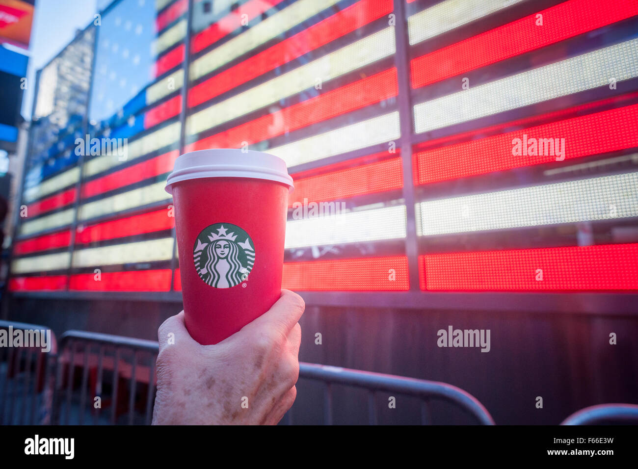 Un buveur de café Starbucks affiche sa tasse de café sur le thème de Noël à New York le dimanche, Novembre 8, 2015. Un groupe de chrétiens évangéliques est offensé par le retrait de l'«symboles de la saison' à partir de la tasse qui sont juste rouge vert et blanc avec le logo de Starbucks. (© Richard B. Levine) Banque D'Images