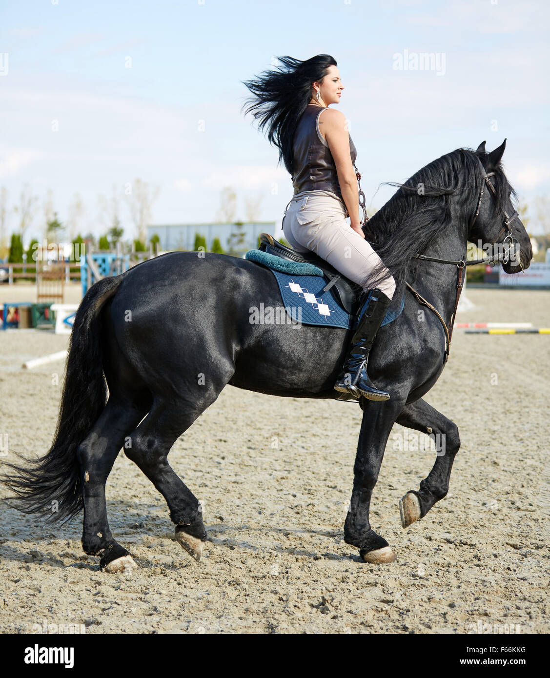 Belle jeune femme à cheval sur un hippodrome Banque D'Images