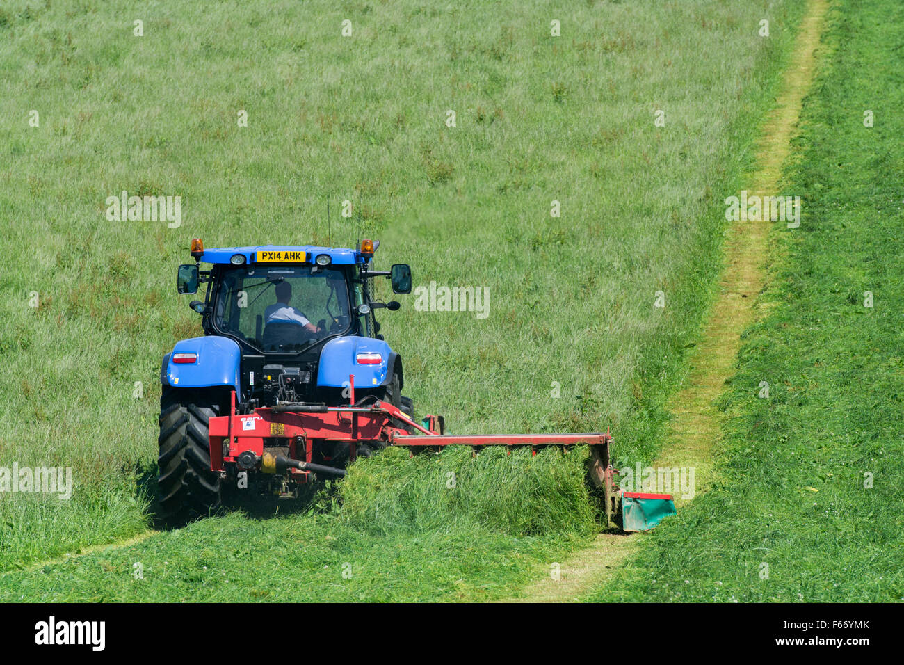 La tonte d'un pré avec un tracteur New Holland T7 avec Kvernland faucheuse conditionneuse frontale et latérale. , Cumbria (Royaume-Uni). Banque D'Images
