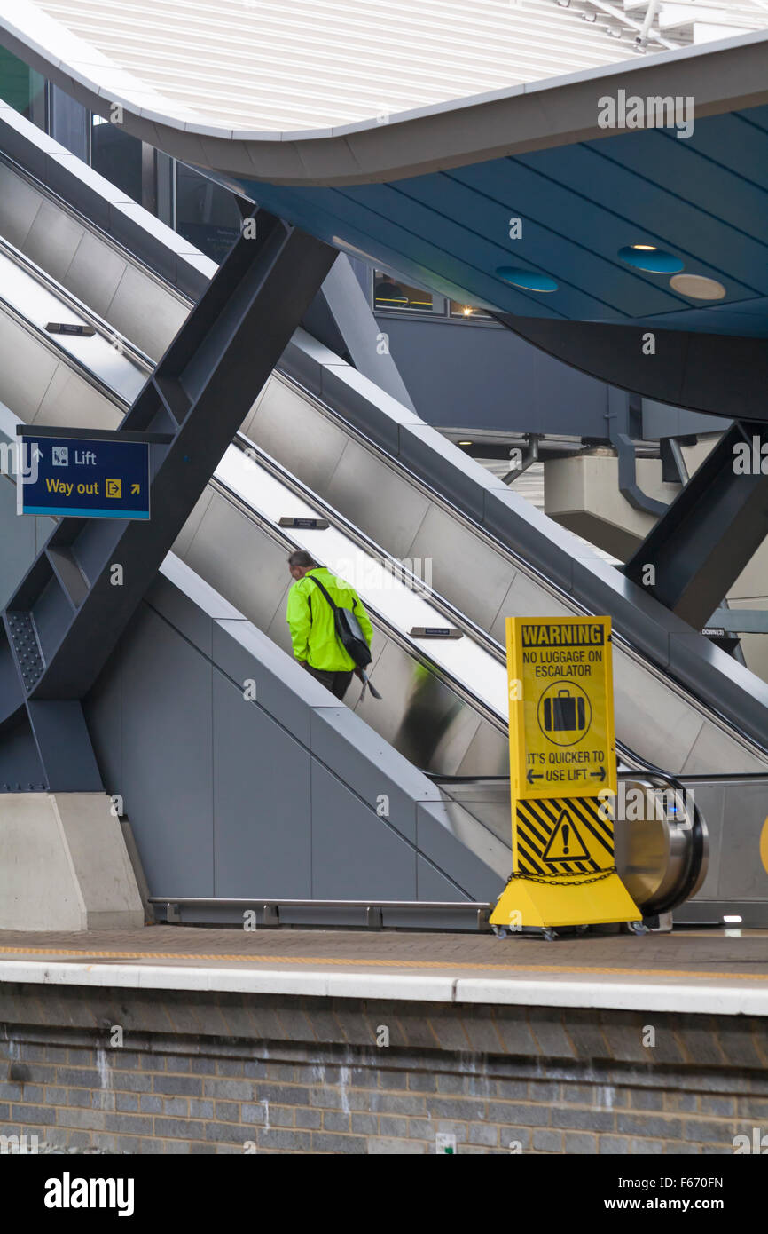L'homme en haute viz jacket de monter sur l'escalator à la gare de Reading en Novembre Banque D'Images