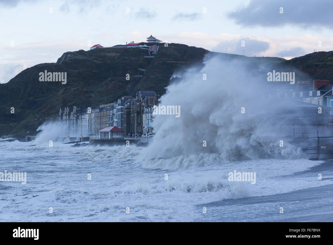 Pays de Galles Aberystwyth UK 13 novembre 2015 Storm Abigail lashes out at Aberystwyth ce matin avec furious vagues tandis que deux constructeurs d'essayer de travailler sur l'échafaudage du nouveau kiosque sur la promenade. Crédit : Ian Jones/Alamy Live News Banque D'Images