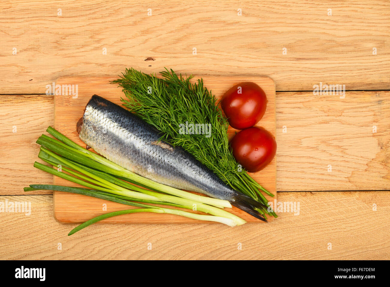 Filet de hareng aux oignons, double de l'aneth et les tomates de bamboo conseil sur la surface de la table en bois vintage Banque D'Images