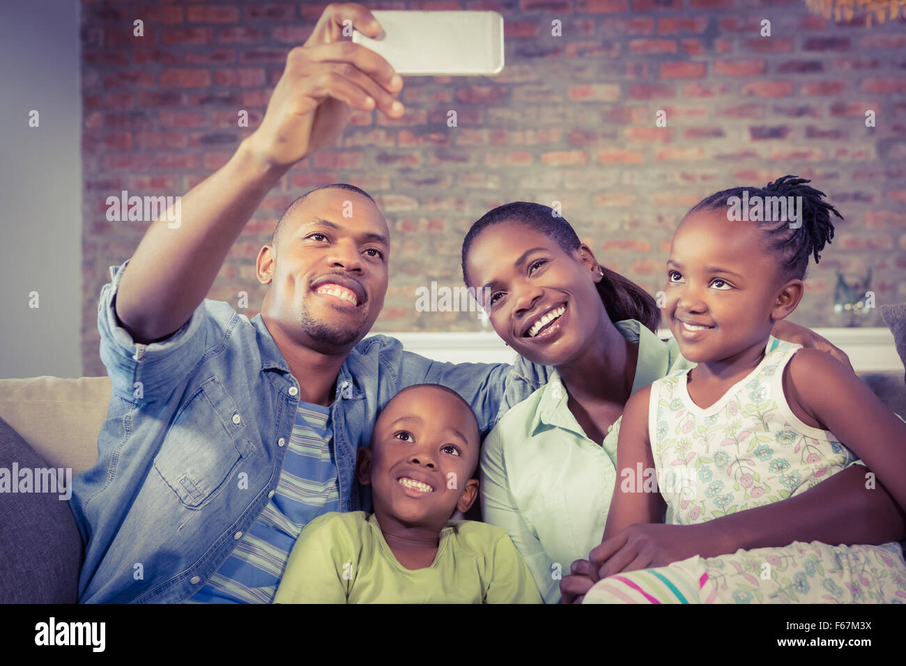 Prendre une famille heureuse sur le canapé selfies Banque D'Images