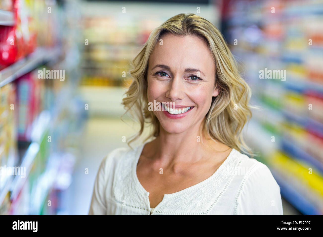 Femme souriante au supermarché Banque D'Images