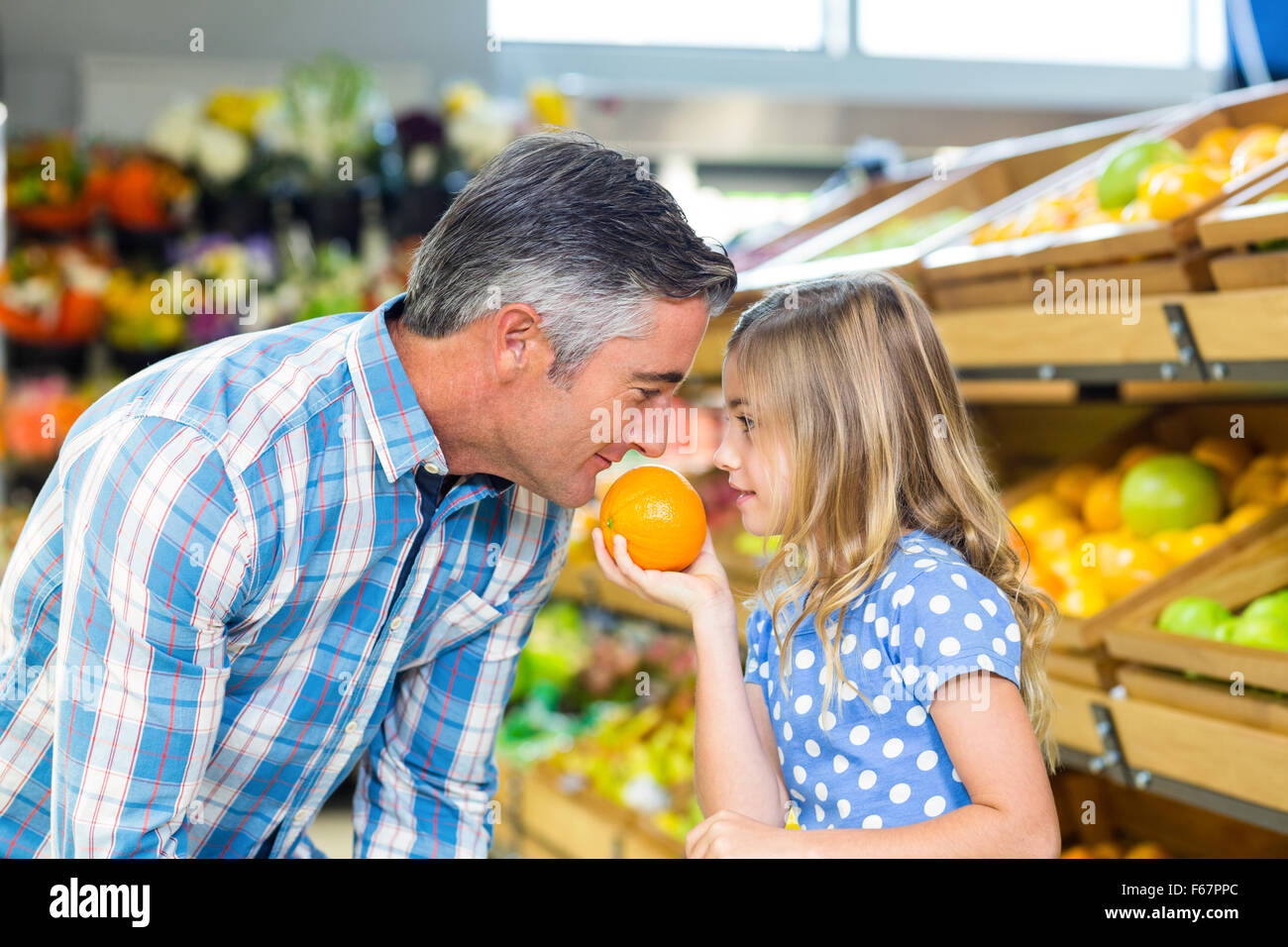 Cute girl holding une orange à son père Banque D'Images
