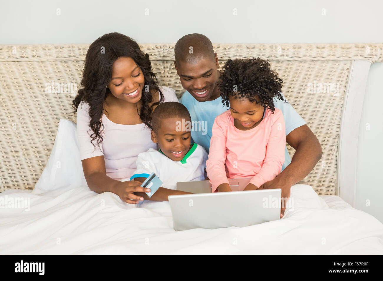Happy Family shopping online with laptop Banque D'Images
