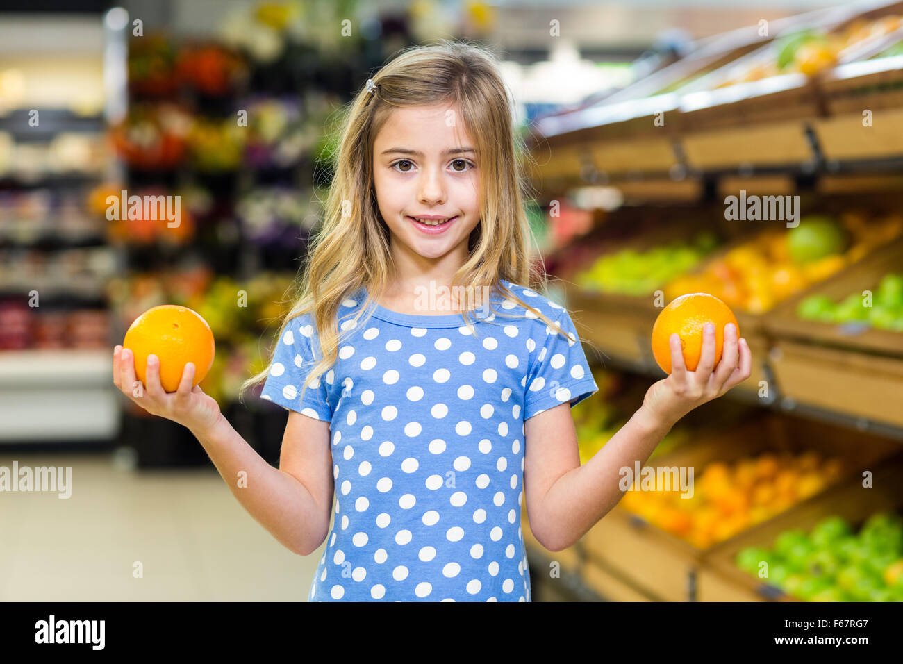 Smiling young girl holding oranges Banque D'Images