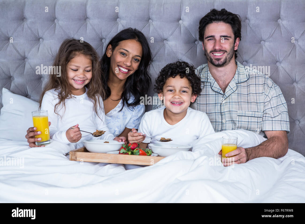 Happy Family having breakfast on bed Banque D'Images